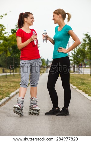 Two friends are talking and drinking water after exercise.Friends talking after exercise