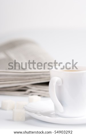 cup of coffee, sugar and stack of newspapers closeup