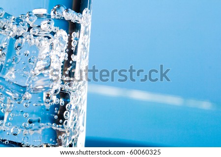 glass with cold water on blue background