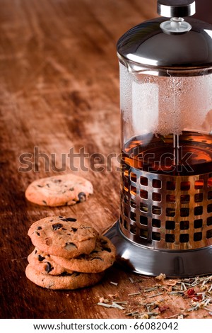 french press with hot tea and fresh baked cookies closeup on wooden table