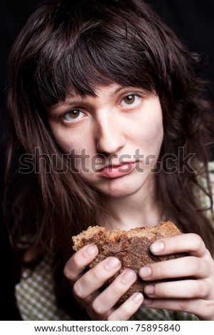 portrait of a poor beggar woman with a piece of bread in her hands