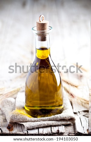 fresh olive oil in bottle on rustic wooden board