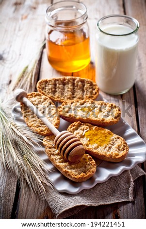 crackers, milk and honey on rustic wooden board