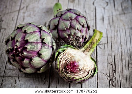 fresh artichokes on rustic wooden background