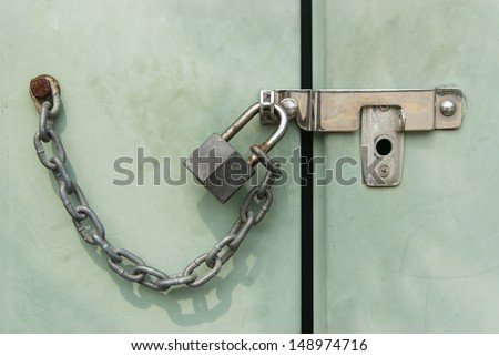 Grunge padlock chained and locked on telephone exchange cabinet