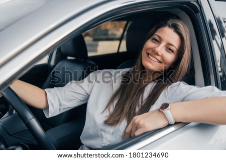 Similar – Image, Stock Photo Young smiling woman steering car at sunset