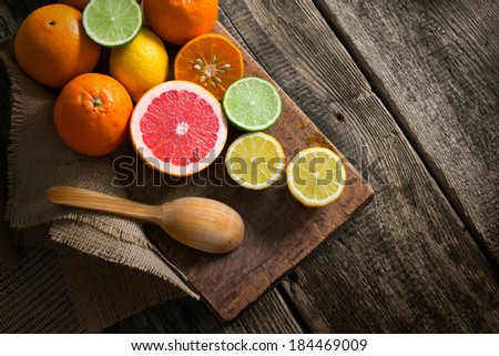 Halves of fresh citrus fruits on wooden background. Orange, grapefruit, lime, lemon, tangerine cut rings.