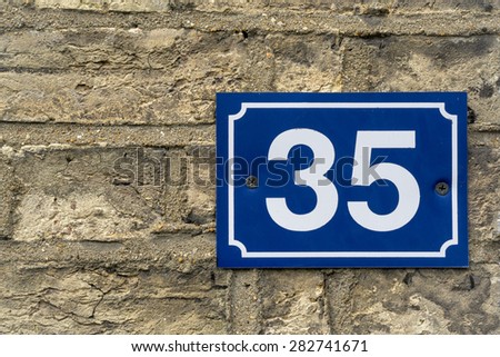 House number 35 thirty five plate on brick wall texture closeup