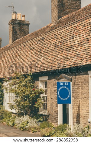 \'To Let\' sign infront of a cottage  vertical image