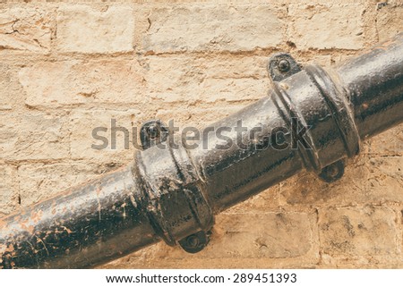 Weathered waste pipe attached on a wall conceptual image