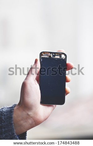 woman holding a broken phone