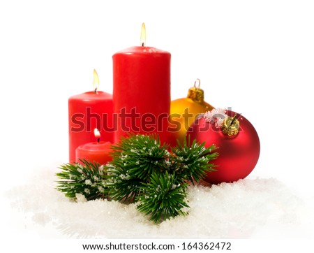 red candles and fir branches and Christmas balls in snow isolated on white