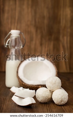coconut,  milk  in a glass bottle and candies on wooden