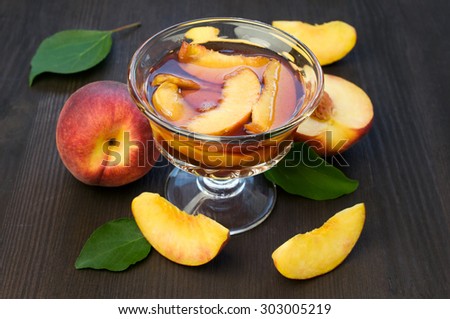 Peach jam and fresh fruits on a black wooden table