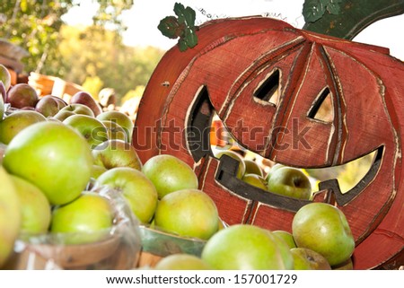 Smiling pumpkin and bushels of apples