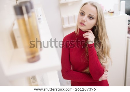 Young woman comparing cosmetics in a cosmetics shop