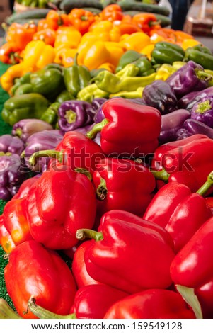 Locally grown organic bell pepper arranged in rainbow display for sale at local farmers market