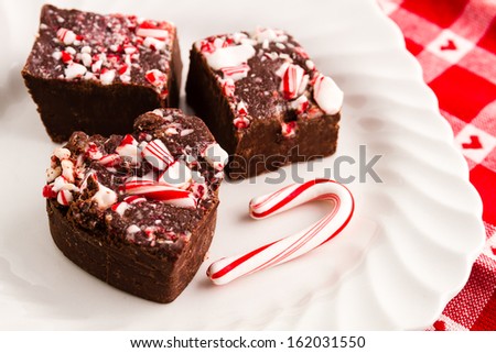 Holiday fudge on white plate with small candy cane