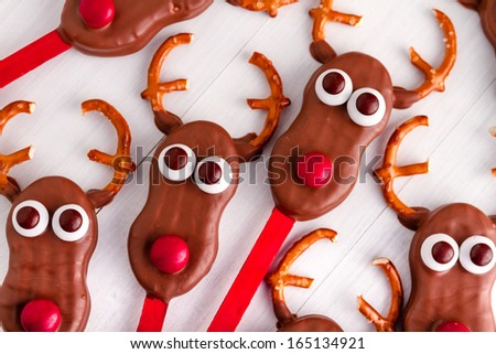 Arrangement of Christmas reindeer cookie pops on white wooden table
