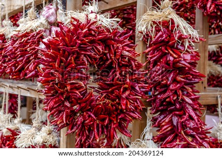Dried red chili pods hanging as decorative chili ristra wreath at local farmers market