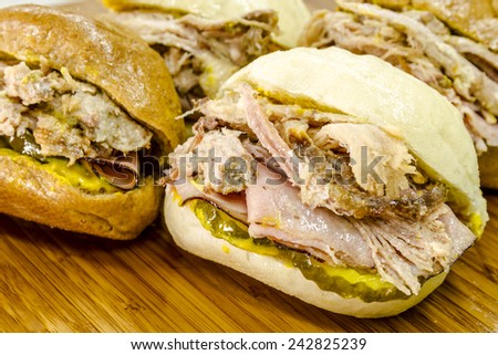 Close up of Cuban Midnight (Medianoche) sandwiches sitting on wooden cutting board