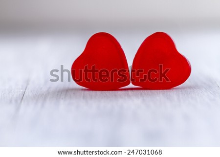 Two cherry jelly heart candies sitting on white background