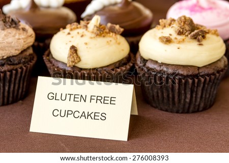 Display of assorted gluten free cupcakes sitting on display table