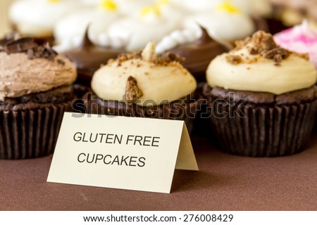 Display of assorted gluten free cupcakes sitting on display table