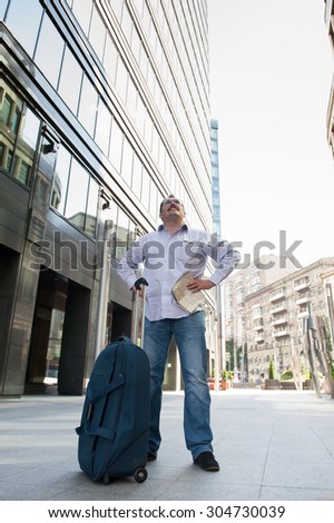 Man with blue bag lookig the wae by city plan
