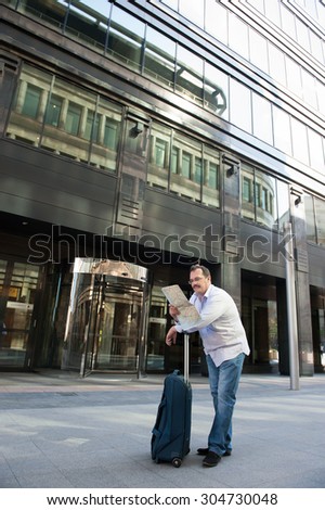 Man with blue bag lookig the wae by city plan