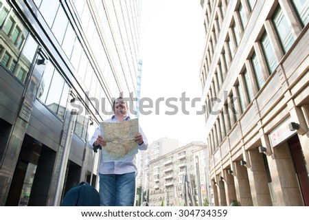 Man with blue bag lookig the way by city plan