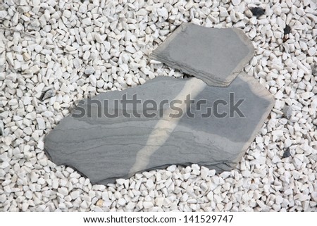 Large stone slabs on white small rock.