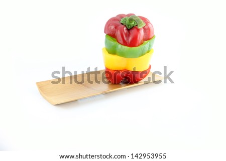 Bell pepper to arranged vertically in bamboo dish on white background.