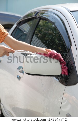 White car washing with fabric and Water hose in house.