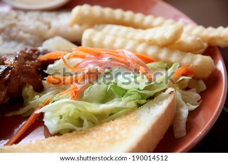 vegetable salad with french fries and toast on dish in restaurant.
