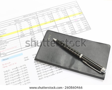 Pen and black notebook placed on the document.