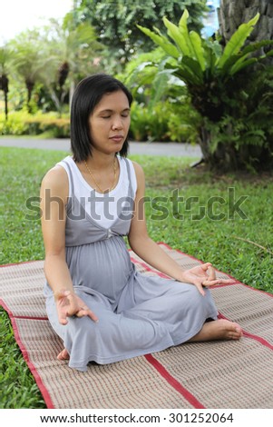 Thai pregnant mom was meditation in the garden for good mental health.