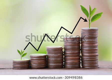 silver coin stack and arrow line in business growth concept on wood floor with colorful nature background.