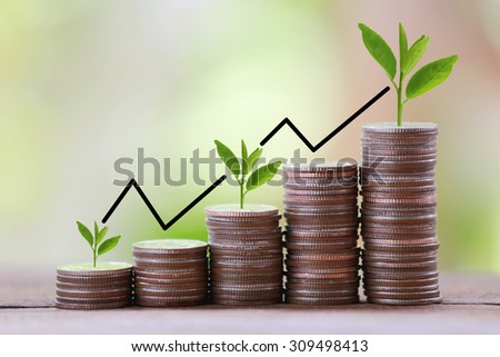 silver coin stack and arrow line in business growth concept on wood floor with colorful nature background.