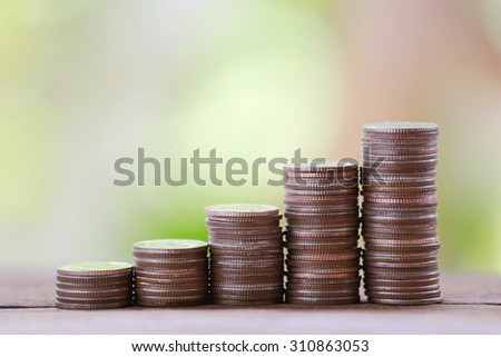 silver coin stack in business growth concept on wood floor with colorful nature background.
