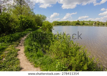 white clouds, blue sky and green nature landscape reflection in water of lake