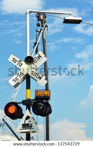 railway sign and traffic lights at a railroad crossing in Thailand