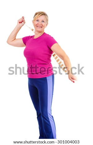 Happy and smile old senior woman dressed in t-shirt color Marsala doing sport fitness exercises with manual wooden masseur for massage of a back, isolated on white background, Positive emotions