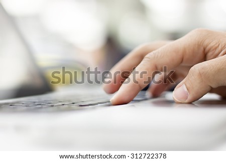 Man\'s hands typing on laptop keyboard