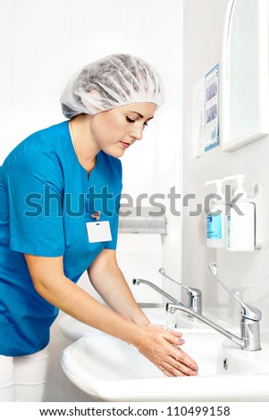 Beautiful nurse, washes his hands before the procedure,wiped his hands dry