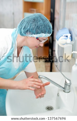 Beautiful nurse, washes his hands before the procedure,wiped his hands dry. midwife washes his hands before delivery. surgical hand washing