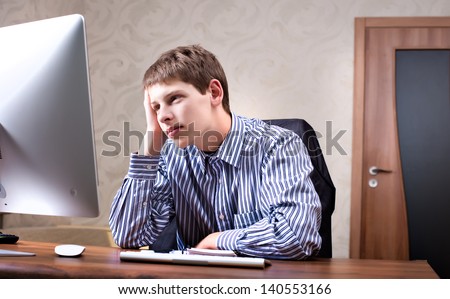 Office worker working at a computer. Man thinks working at a computer