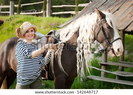 Woman caring for a horse.