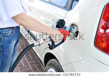 To fill the machine with fuel. Mashunya fill with gasoline at a gas station. Gas station pump. Man filling gasoline fuel in car holding nozzle. Close up.