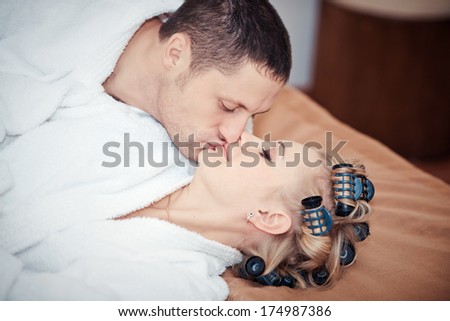 man and woman kissing while lying on the bed. Young lovers lay in bed